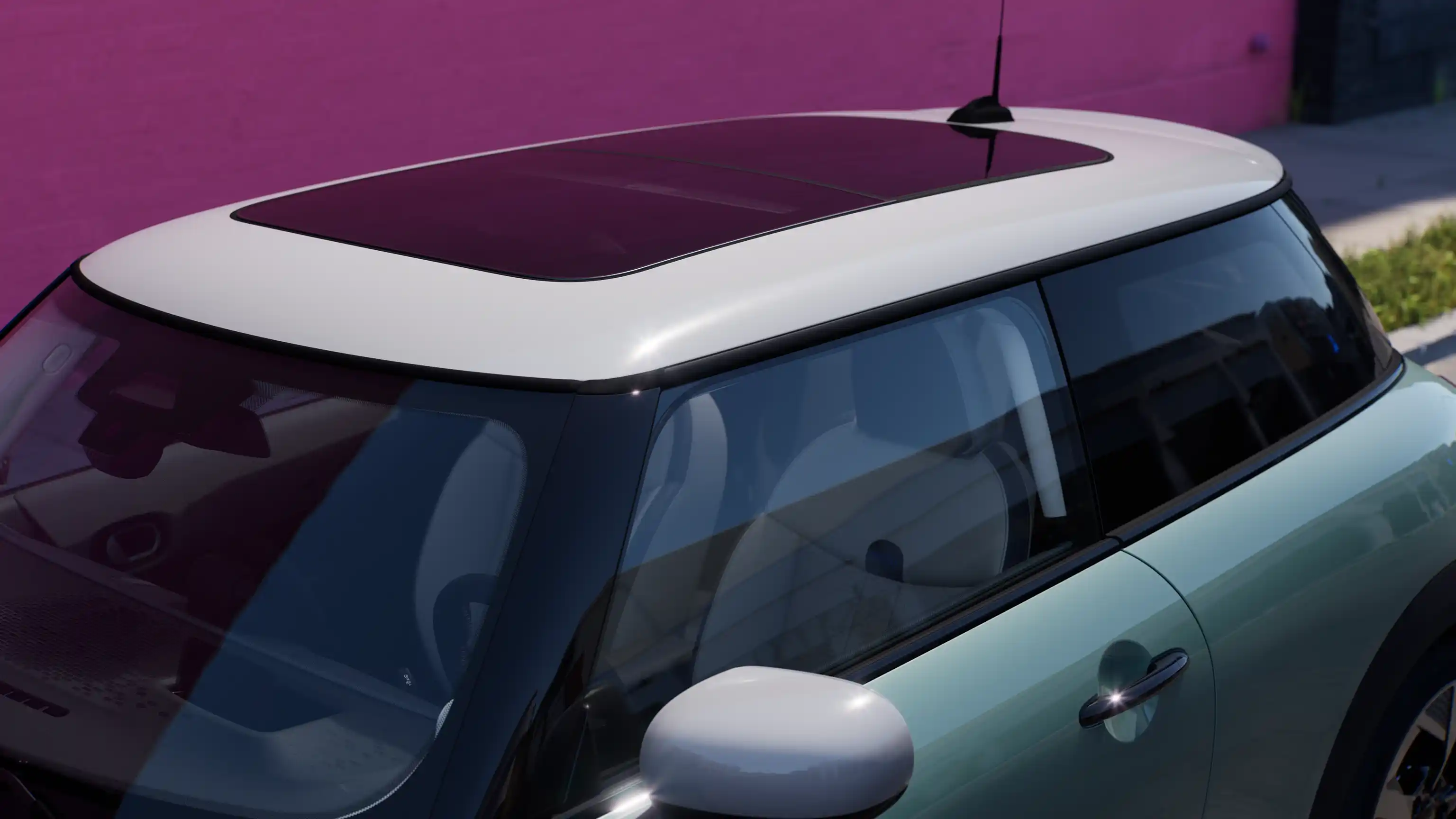 Pogled od zgoraj na MINI Cooper v barvi Ocean Wave Green s kontrastno streho in panoramsko stekleno streho.