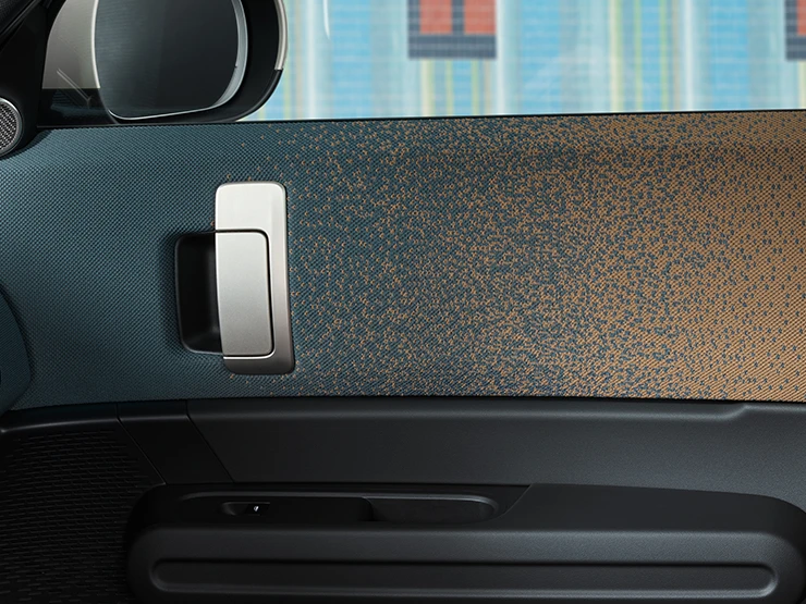 Bližnji pogled na notranjo zasnovo električnega MINI Countryman s poudarkom na vratih in armaturni plošči.