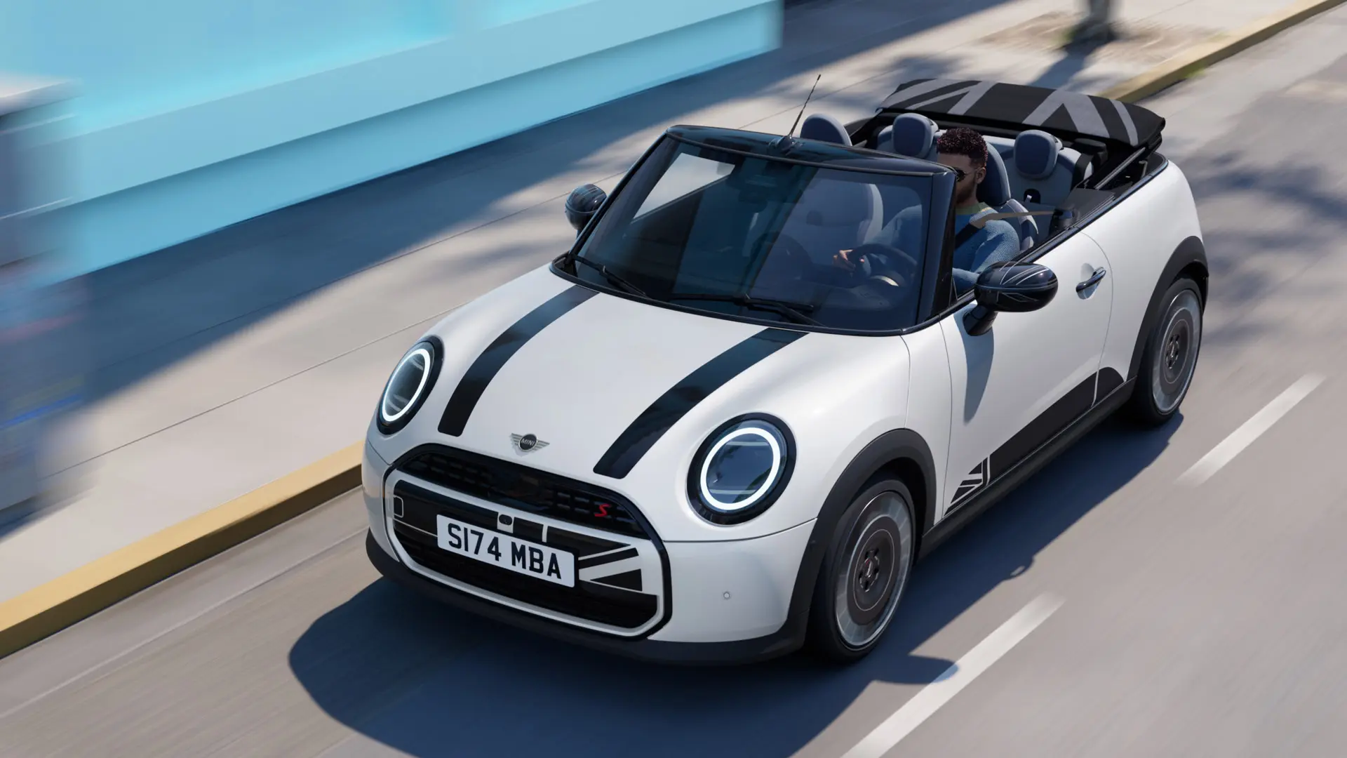 Pogled od zgoraj na MINI Cabrio v barvi Nanuq White z nalepkami za sprednji pokrov MINI Heritage v črni barvi. 