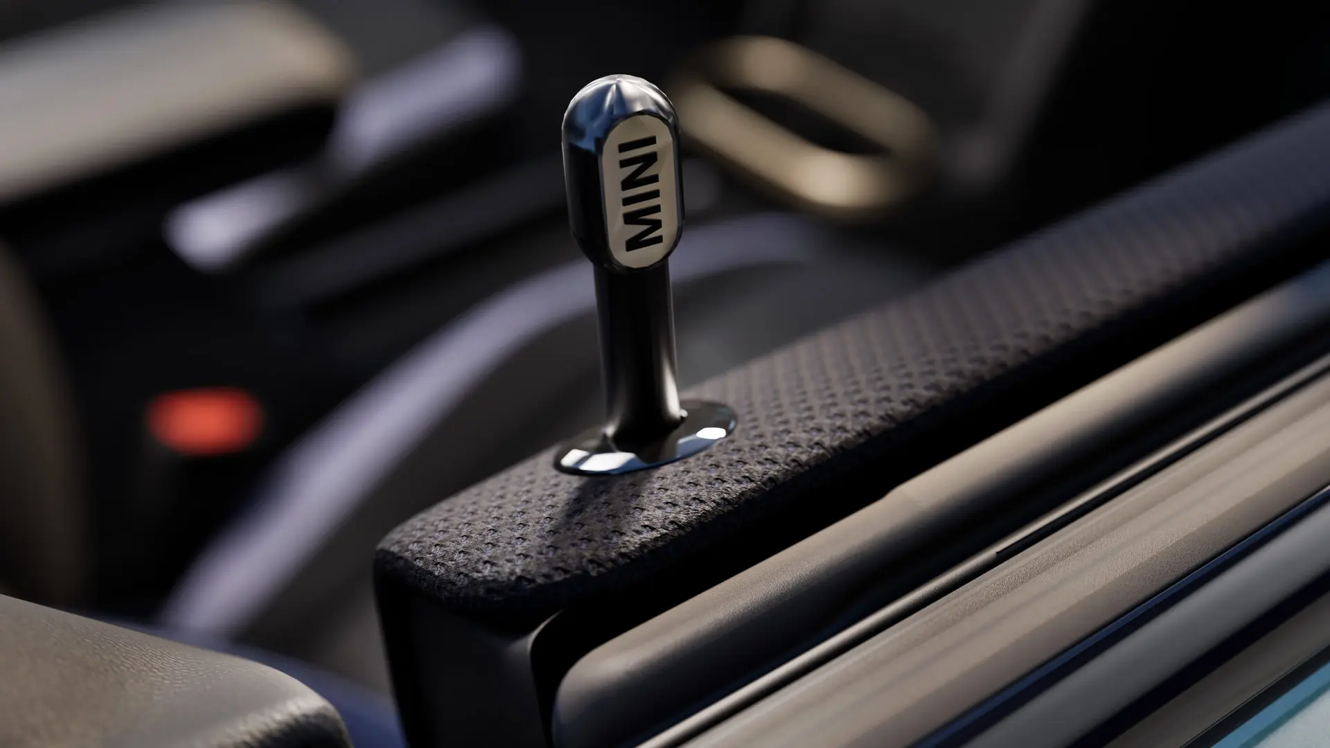 Pogled od blizu na originalni zaklepni zatič za vrata MINI iz črno eloksiranega aluminija.