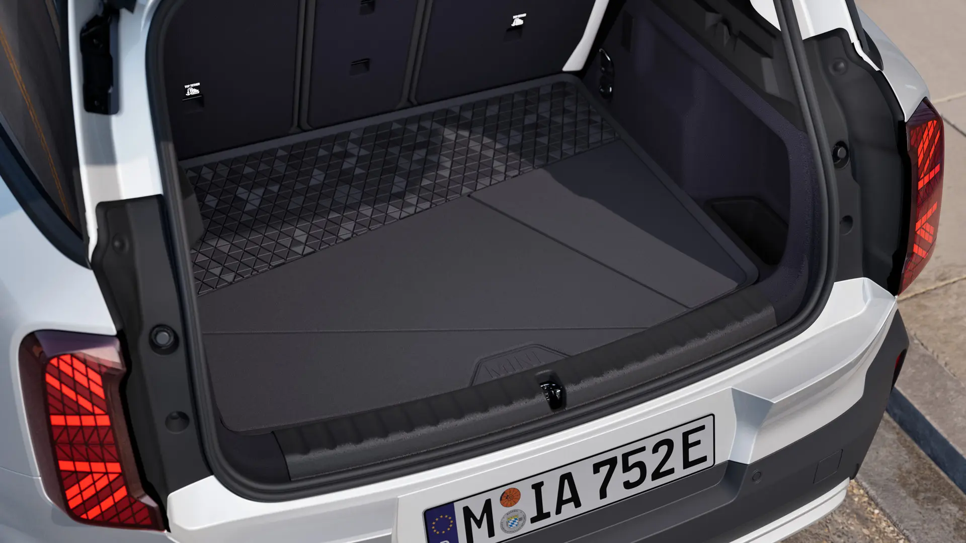 Črna, po meri izdelana preproga za prtljažnik MINI z visokim robom za zaščito pred umazanijo in vlago.