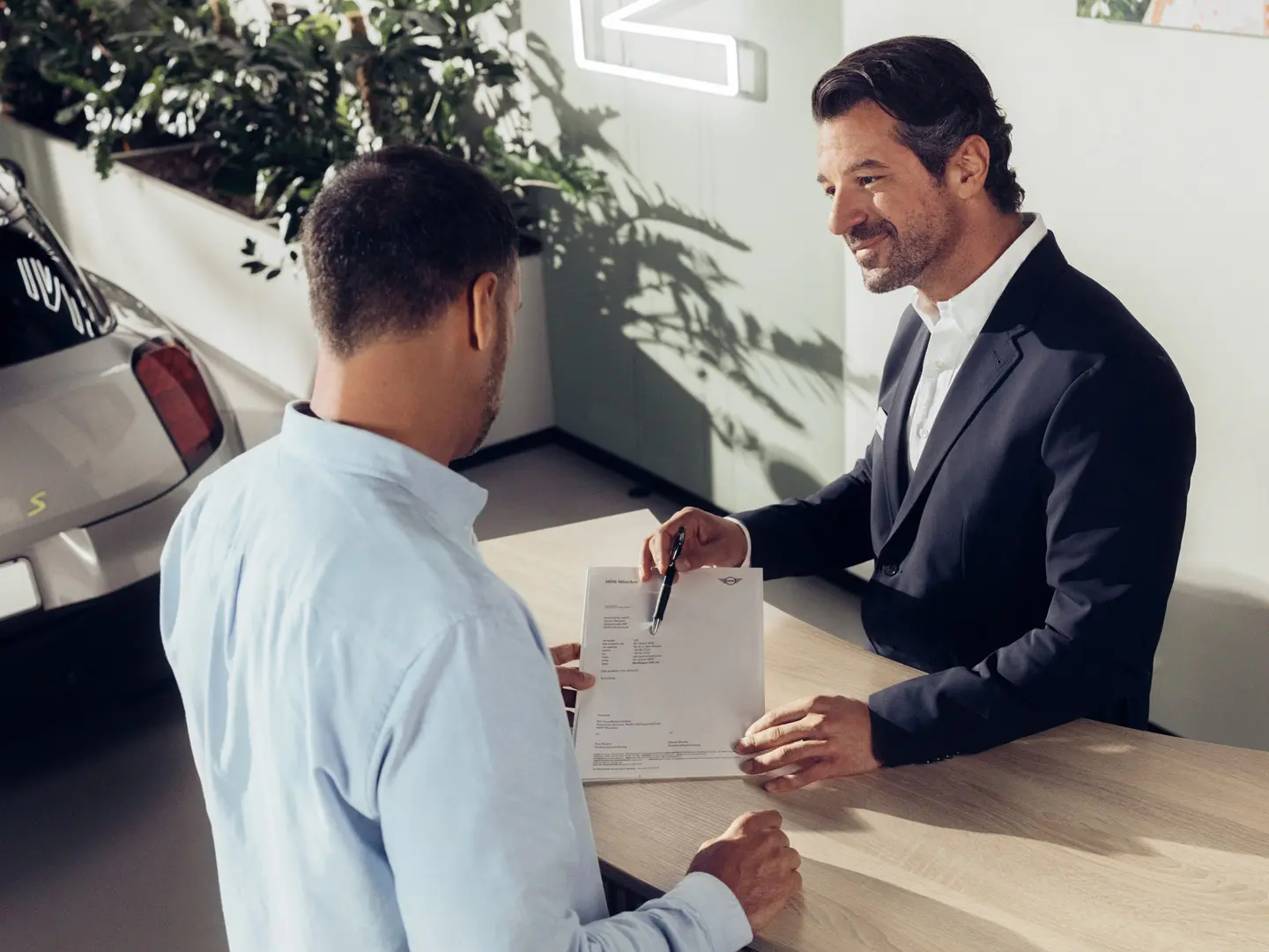 Servisni tehnik pooblaščenega servisa MINI svetuje stranki glede možnosti zavarovanja pnevmatik MINI.