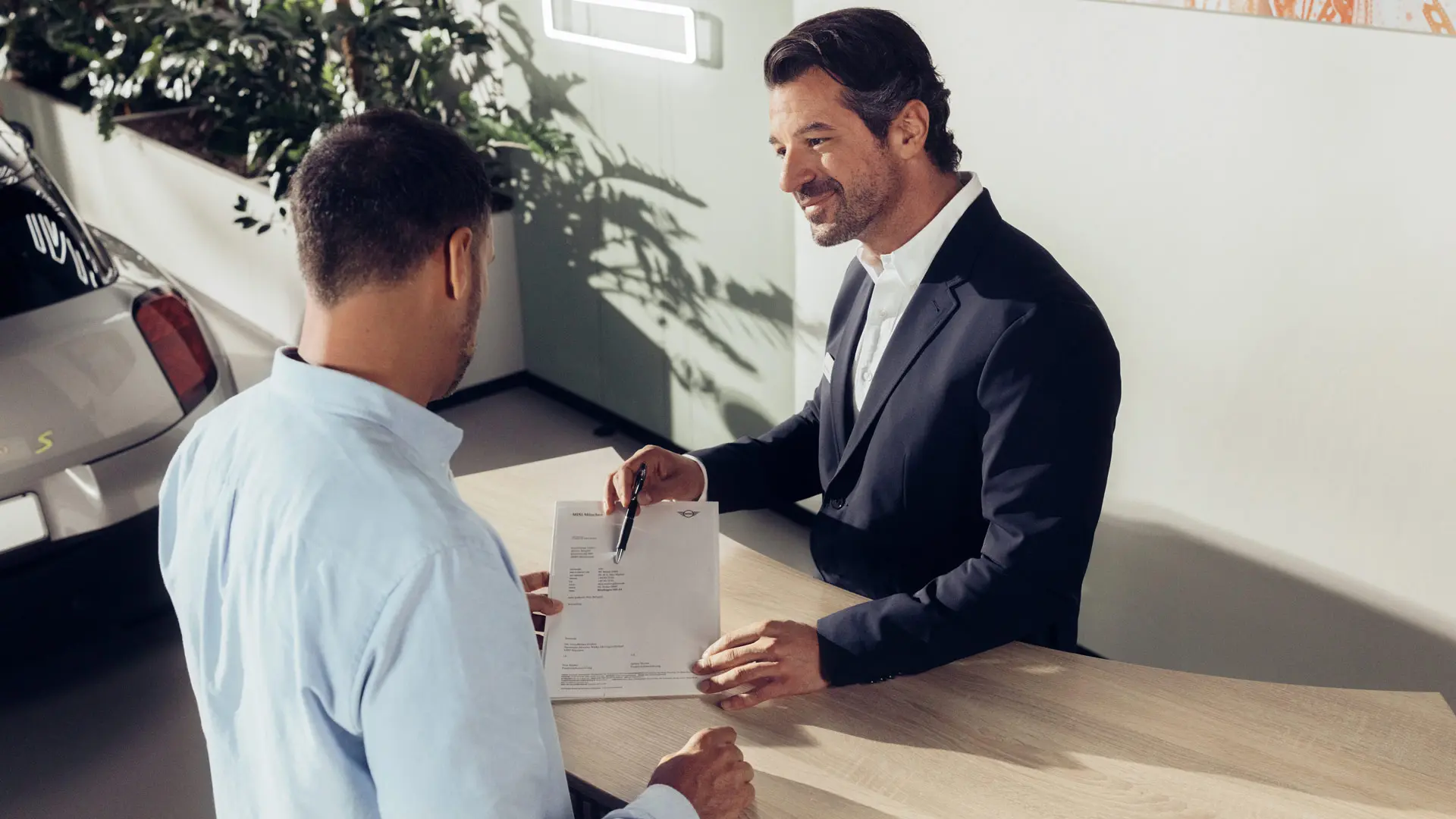 Servisni tehnik pooblaščenega servisa MINI svetuje stranki glede možnosti zavarovanja pnevmatik MINI.