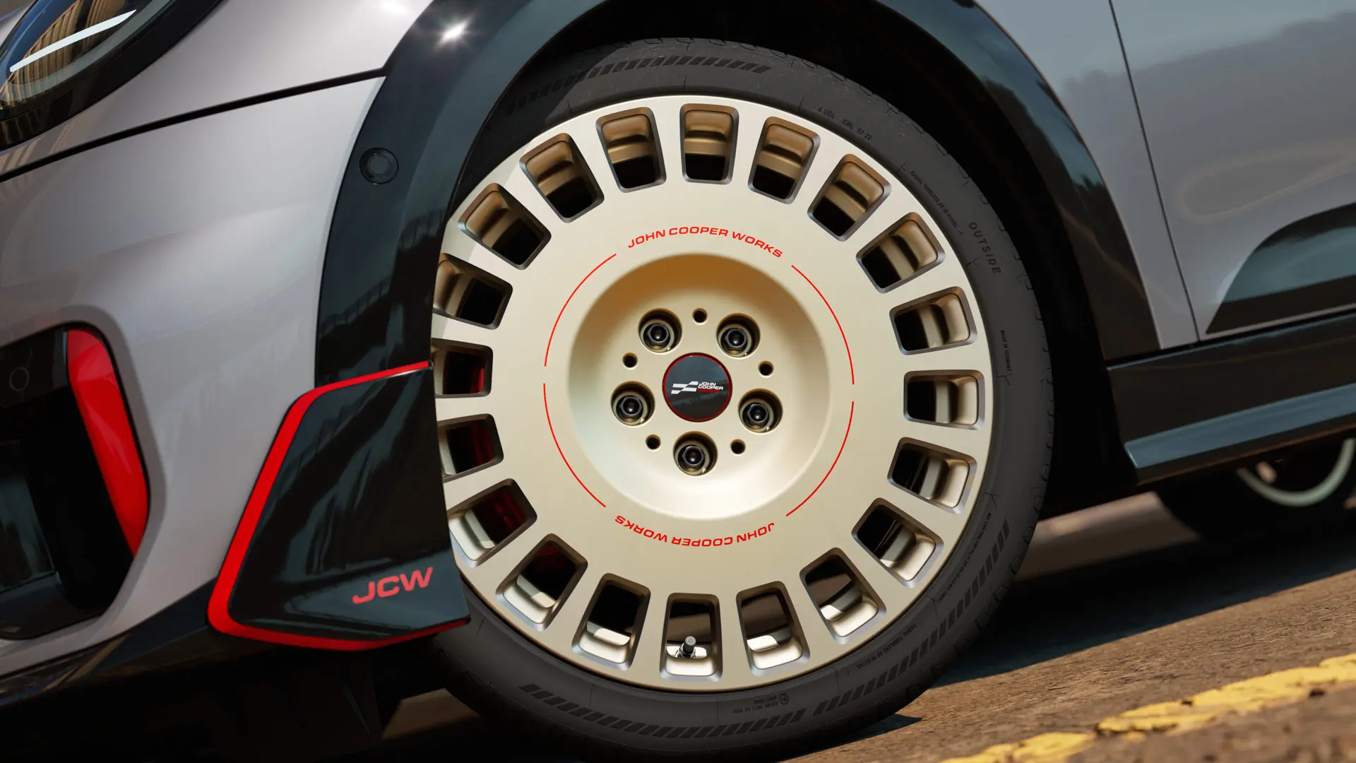 Bližnji posnetek 18-palčnega kolesa JCW Rallye Spoke 964 v dvobarvni kombinaciji Vibrant Silver z diamantno obdelavo in sprednjim zakrilcem.