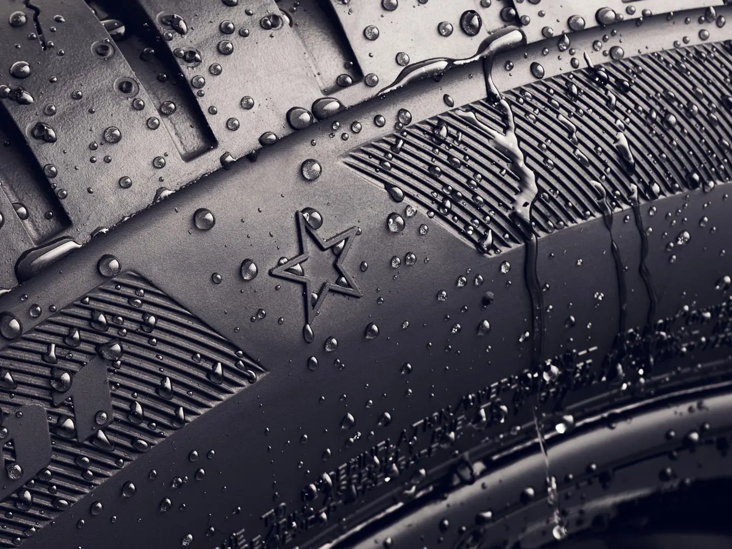 Bližnji posnetek boka pnevmatike s simbolom zvezdice, ki označuje, da je pnevmatika odobrena za optimalno zmogljivost na vozilih MINI. 