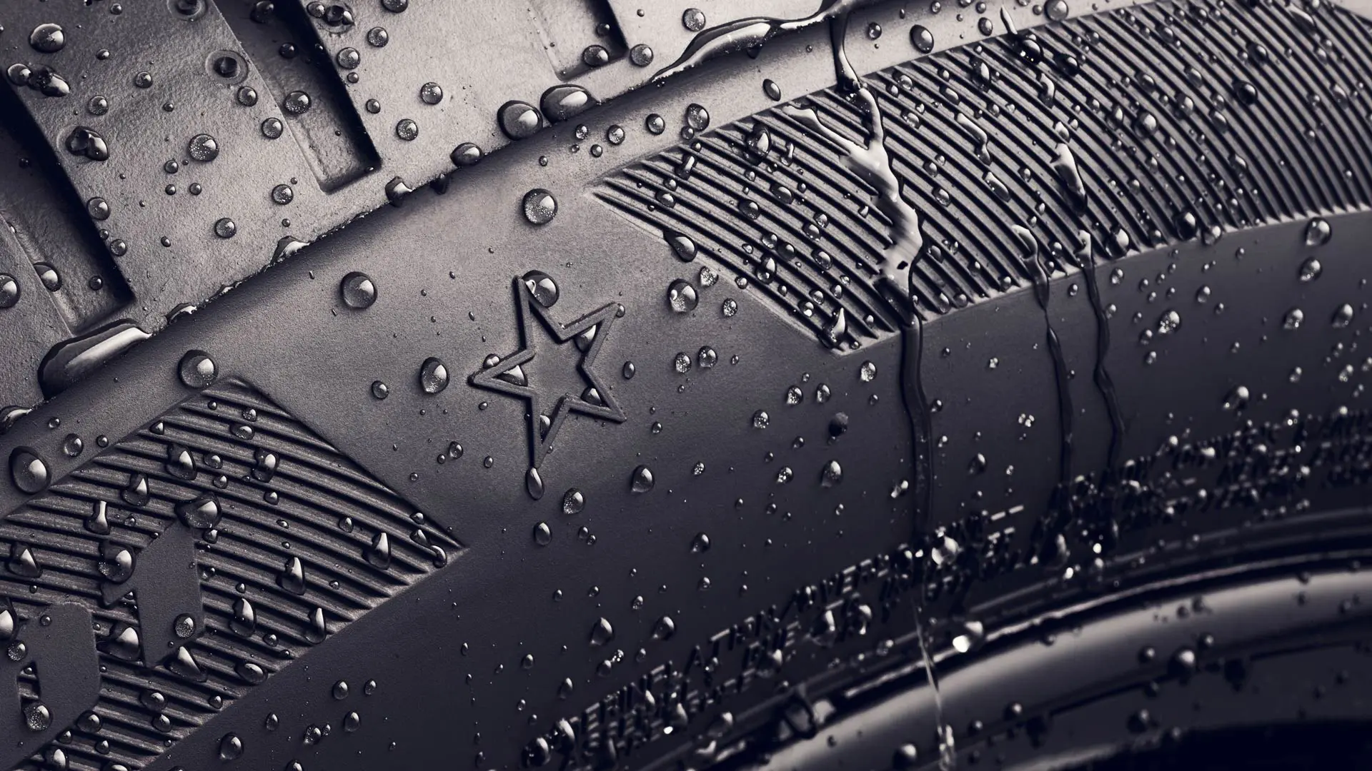 Bližnji posnetek boka pnevmatike s simbolom zvezdice, ki označuje, da je pnevmatika odobrena za optimalno zmogljivost na vozilih MINI. 