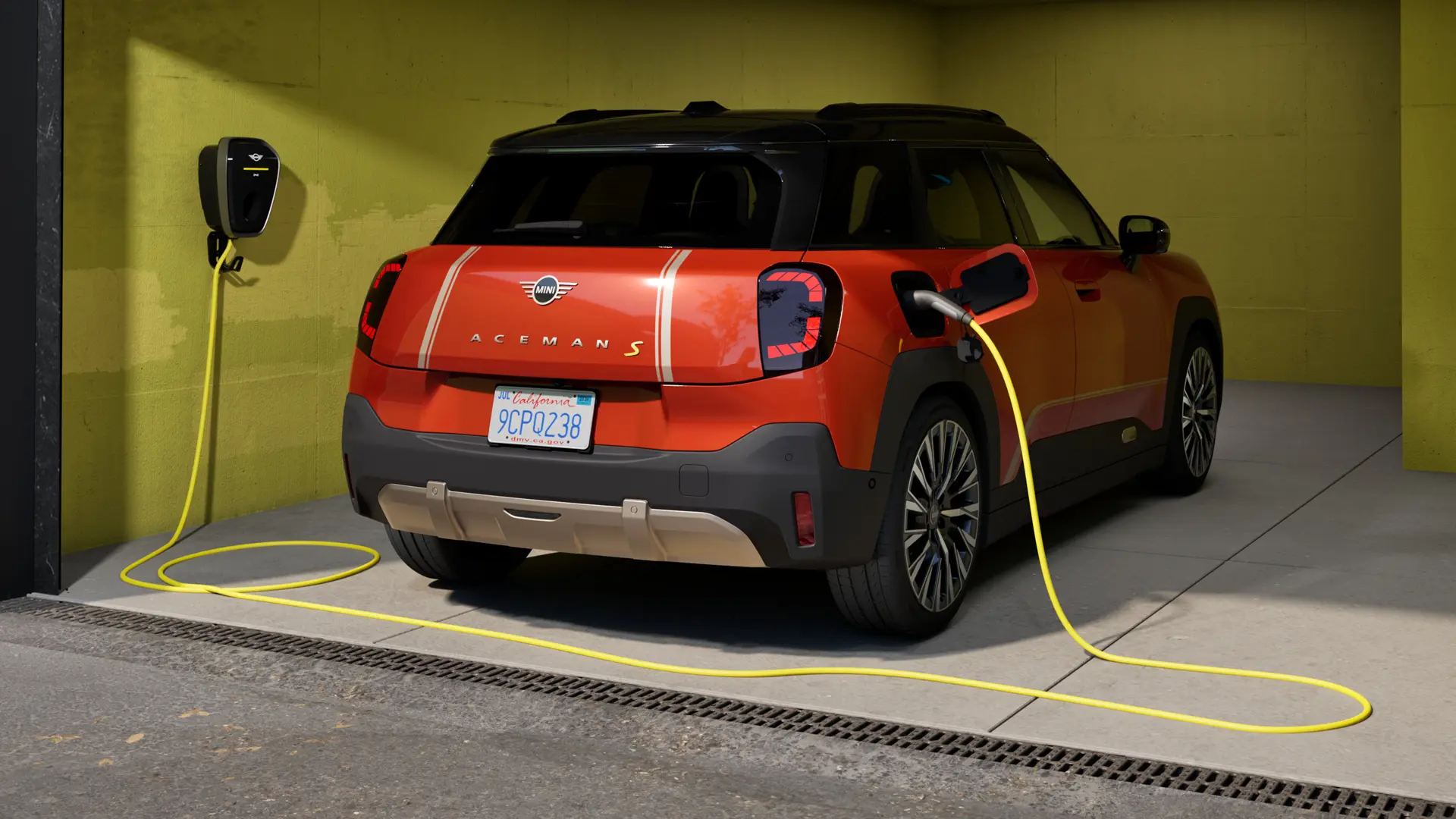 Popolnoma električni MINI Aceman S se polni z MINI Wallbox Plus, pogled od zadaj, parkiran v garaži.