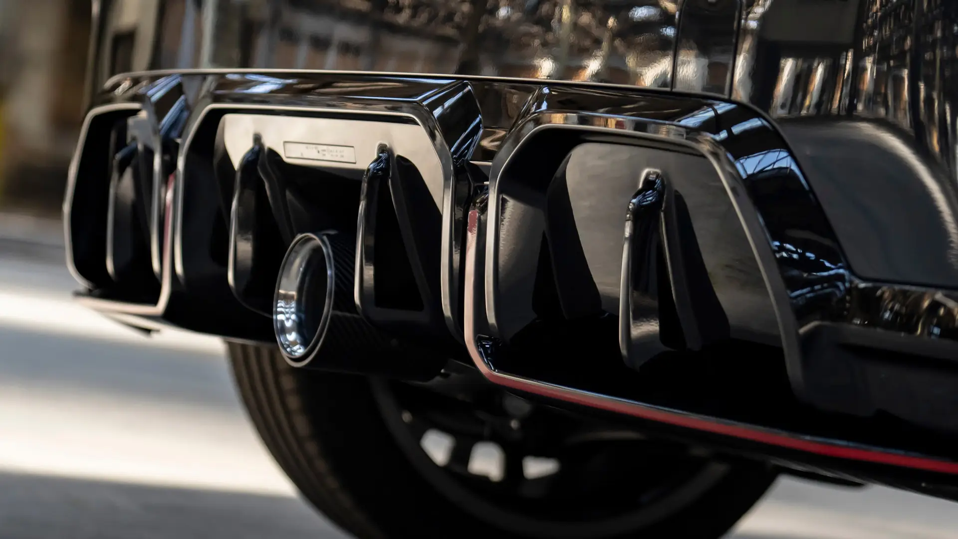 Zadnji difuzor MINI John Cooper Works v črni barvi z visokim sijajem in rdečim okvirjem.