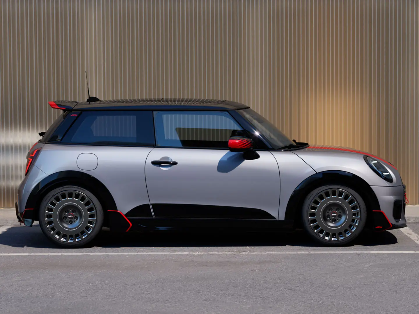 MINI Cooper, 3-vratni, v barvi Melting Silver s strešnim spojlerjem John Cooper Works za izboljšane aerodinamične lastnosti – pogled s strani.