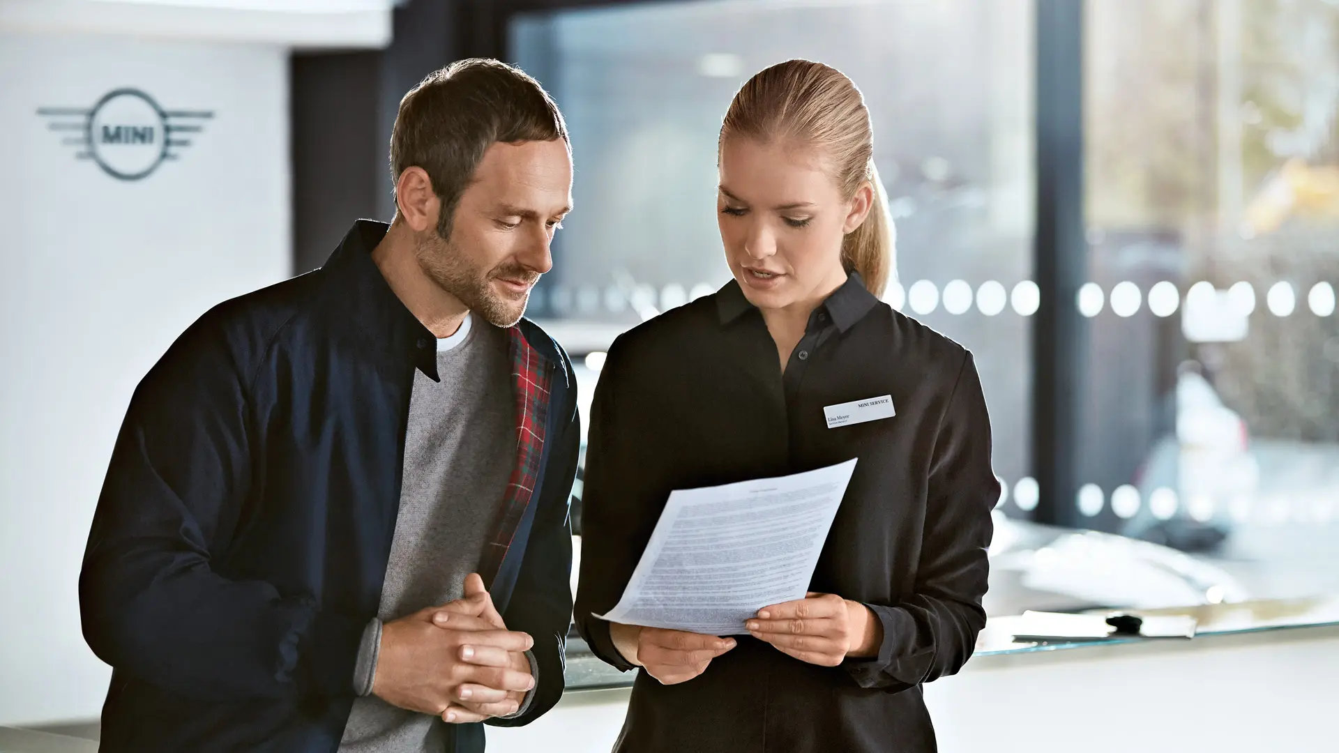 Servisni svetovalec MINI svetuje strankam glede načrta vzdrževanja v centru MINI.