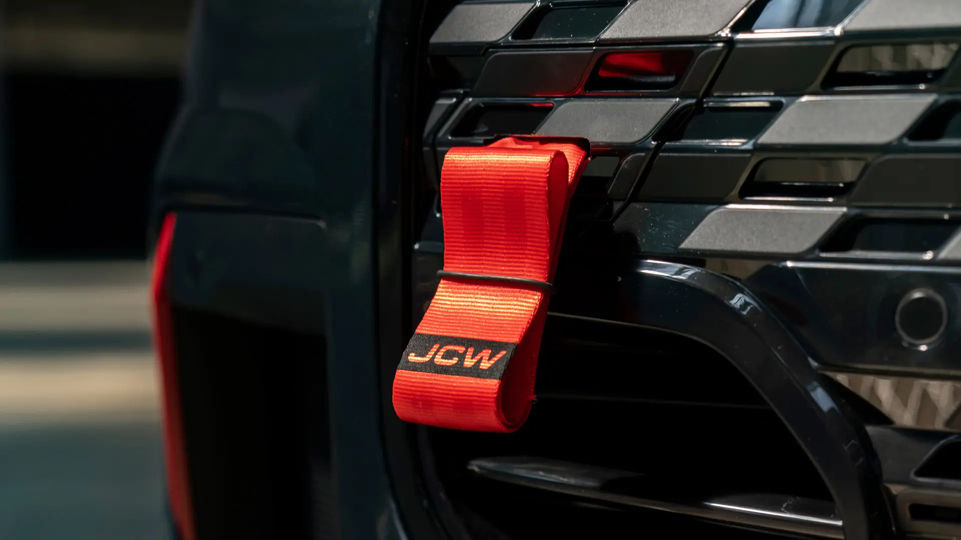 Rdeči vlečni trak MINI John Cooper Works s črnim logotipom JCW ima dolžino droga 90 mm.