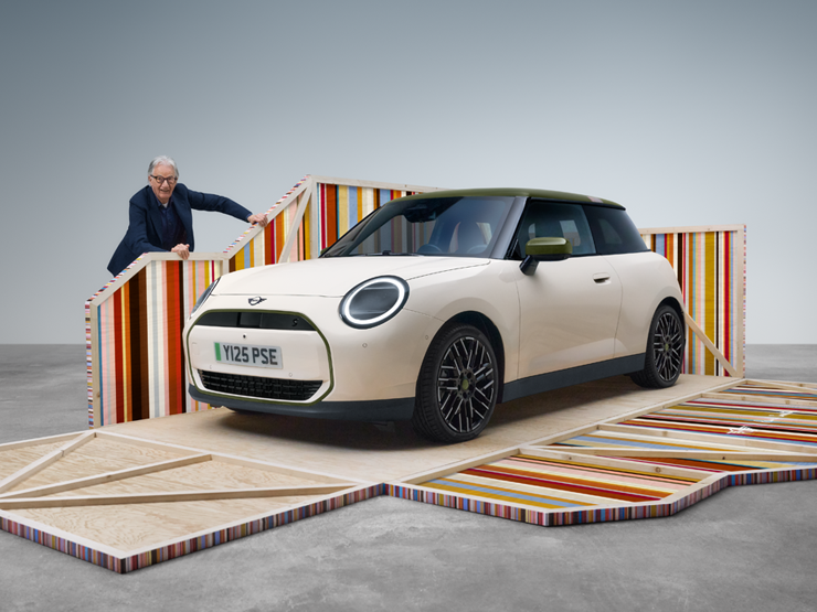 Pogled od spredaj na električni MINI Cooper Paul Smith Edition v barvi Inspired White z oblikovalcem Paulom Smithom