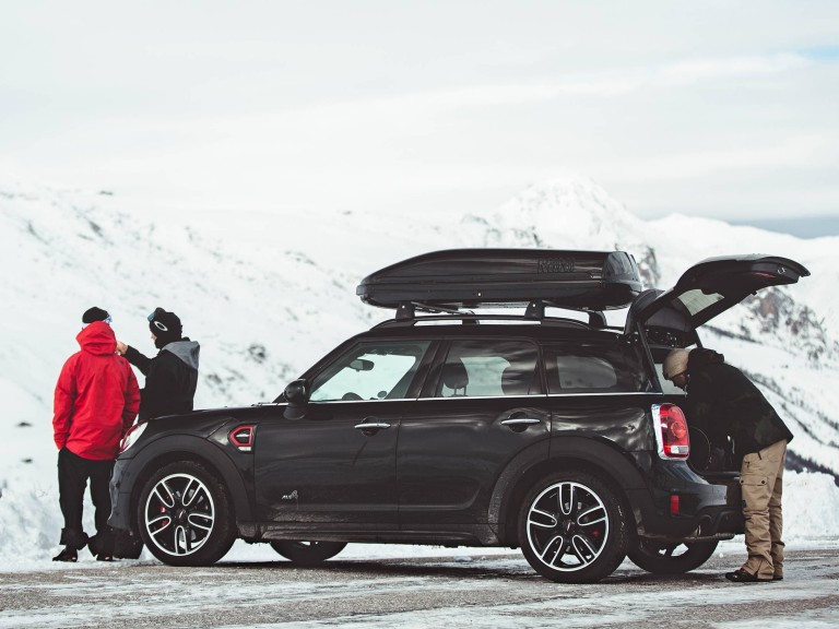 MINI Countryman črne barve – pogled od zadaj – zasnežene gore